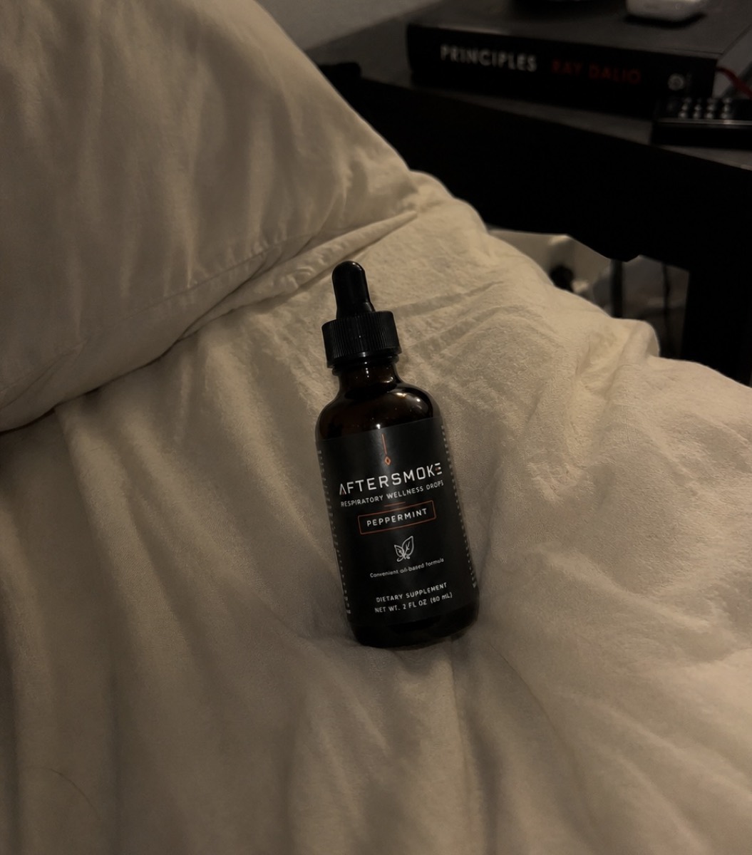 AfterSmoke bottle resting on bedding at the end of the day